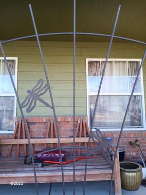 Neat handmade rustic plant stand with bowling ball center and a heavy metal Dragonfly Trellis