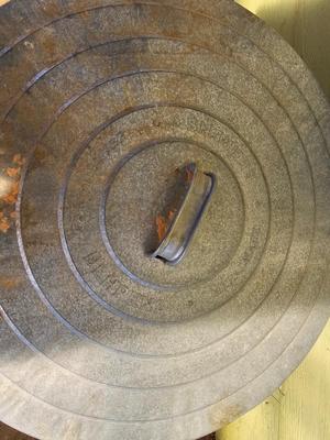 Galvanized metal trash can with lid and a push broom