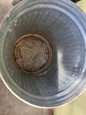 Galvanized metal trash can with lid and a push broom