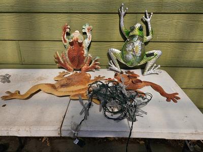 Four metal garden frogs and a strand of dragonfly lights