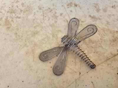 Four metal garden frogs and a strand of dragonfly lights