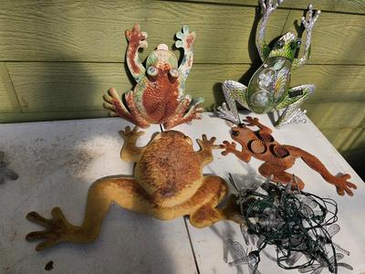 Four metal garden frogs and a strand of dragonfly lights
