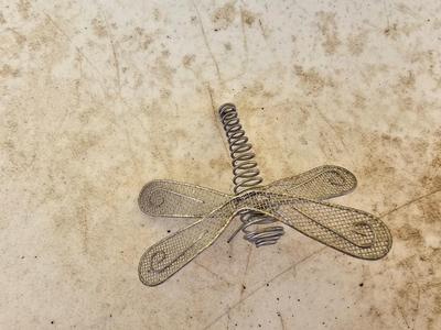 Four metal garden frogs and a strand of dragonfly lights