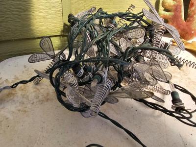 Four metal garden frogs and a strand of dragonfly lights