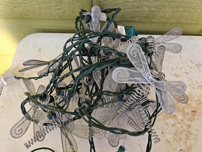 Four metal garden frogs and a strand of dragonfly lights
