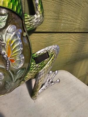 Four metal garden frogs and a strand of dragonfly lights