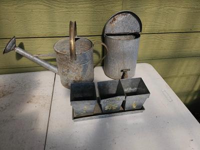 Galvanized watering can, waterer with a pout, and three herb pots with a tray