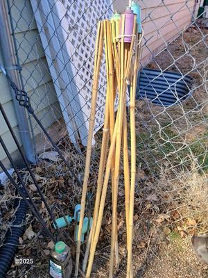 Four metal tiki torches - Bamboo torches with a jug of tiki fuel