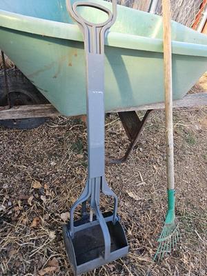 Large sized plastic wheelbarrow with a poop scooper and small rake