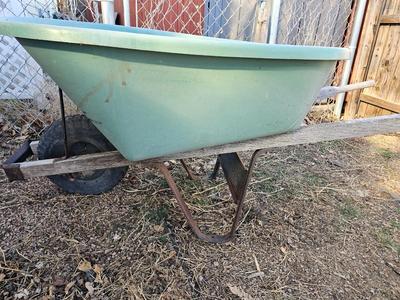 Large sized plastic wheelbarrow with a poop scooper and small rake