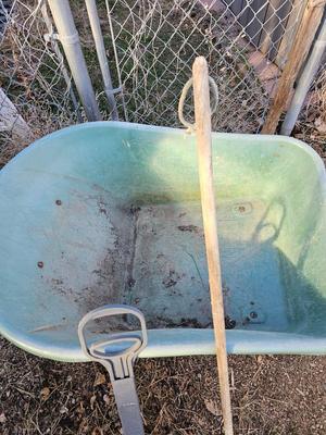 Large sized plastic wheelbarrow with a poop scooper and small rake