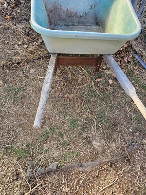 Large sized plastic wheelbarrow with a poop scooper and small rake