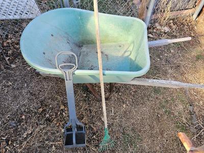 Large sized plastic wheelbarrow with a poop scooper and small rake