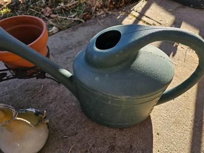 3 tiered plant stand with 3 terra cotta pots, small garden handtools, and watering can