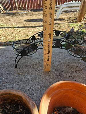 3 tiered plant stand with 3 terra cotta pots, small garden handtools, and watering can
