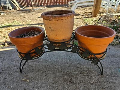 3 tiered plant stand with 3 terra cotta pots, small garden handtools, and watering can