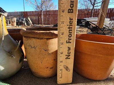 3 tiered plant stand with 3 terra cotta pots, small garden handtools, and watering can