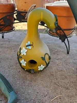 3 tiered plant stand with 3 terra cotta pots, small garden handtools, and watering can