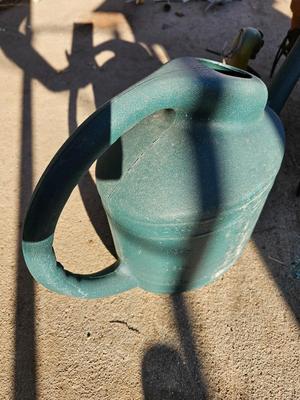 3 tiered plant stand with 3 terra cotta pots, small garden handtools, and watering can