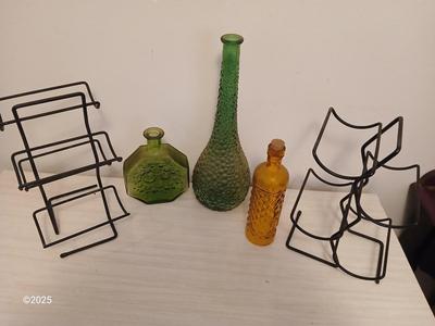 Three Unique glass bottles with two metal tabletop wine racks