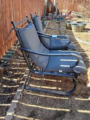 Two metal patio chairs with cushions