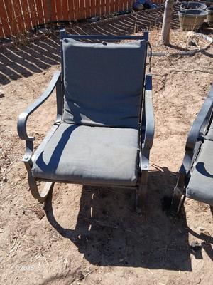 Two metal patio chairs with cushions
