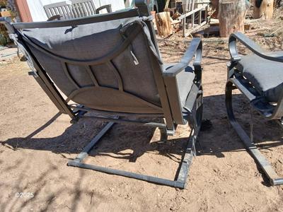 Two metal patio chairs with cushions