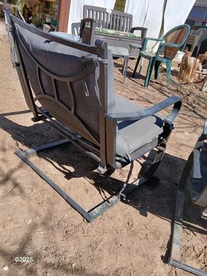 Two metal patio chairs with cushions