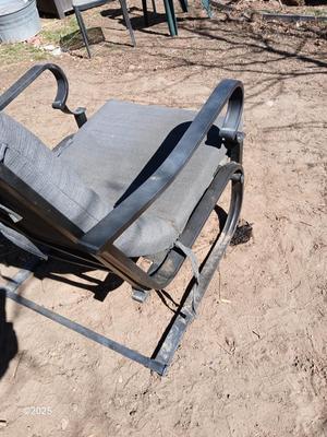Two metal patio chairs with cushions