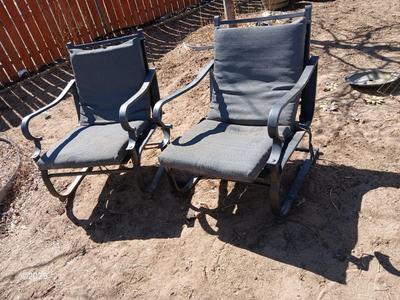 Two metal patio chairs with cushions