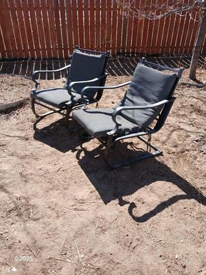 Two metal patio chairs with cushions