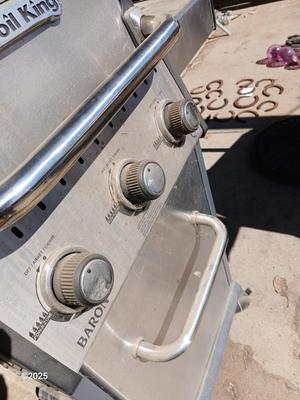Duraflame Broil King Chrome BBQ grill with propane bottle