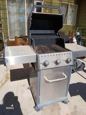 Duraflame Broil King Chrome BBQ grill with propane bottle