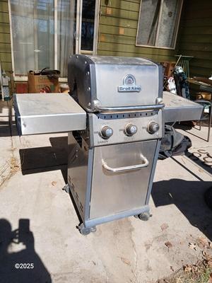 Duraflame Broil King Chrome BBQ grill with propane bottle