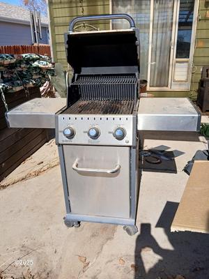 Duraflame Broil King Chrome BBQ grill with propane bottle