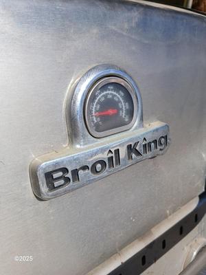 Duraflame Broil King Chrome BBQ grill with propane bottle