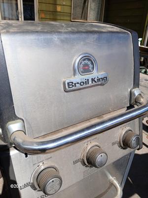 Duraflame Broil King Chrome BBQ grill with propane bottle