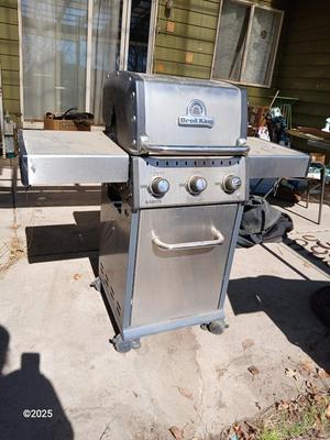 Duraflame Broil King Chrome BBQ grill with propane bottle
