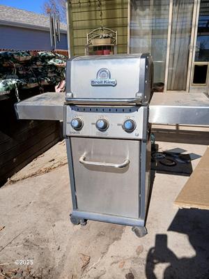 Duraflame Broil King Chrome BBQ grill with propane bottle