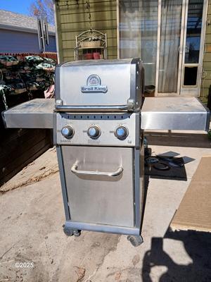 Duraflame Broil King Chrome BBQ grill with propane bottle