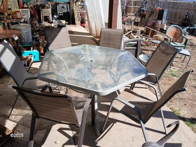 HUGE patio table with leaf imprint design on glass, 6 patio chairs and an umbrella stand