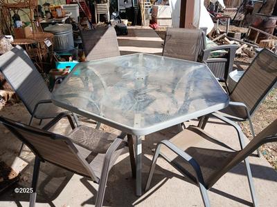 HUGE patio table with leaf imprint design on glass, 6 patio chairs and an umbrella stand