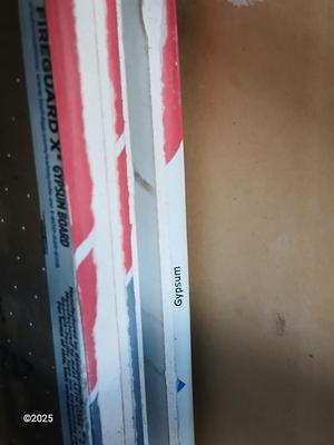 Four sheets of Fireguard X Gypsum board / Drywall with a Stanley Panel carry tool