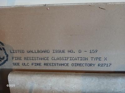 Four sheets of Fireguard X Gypsum board / Drywall with a Stanley Panel carry tool