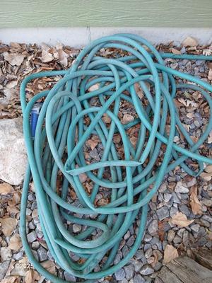 Large green planter - flowerpot - pot with a garden hose