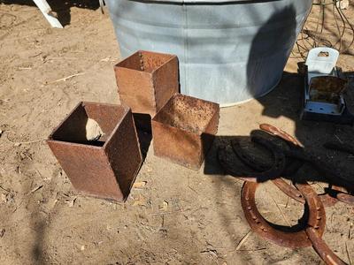 Galvanized tub with an assortment of horseshoes and metal boxes and an old can crsher