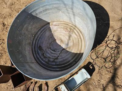 Galvanized tub with an assortment of horseshoes and metal boxes and an old can crsher