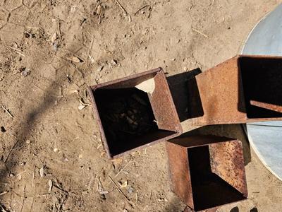 Galvanized tub with an assortment of horseshoes and metal boxes and an old can crsher