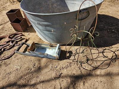Galvanized tub with an assortment of horseshoes and metal boxes and an old can crsher