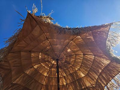 Tiki straw umbrella with stand and three rolls of bamboo wall art